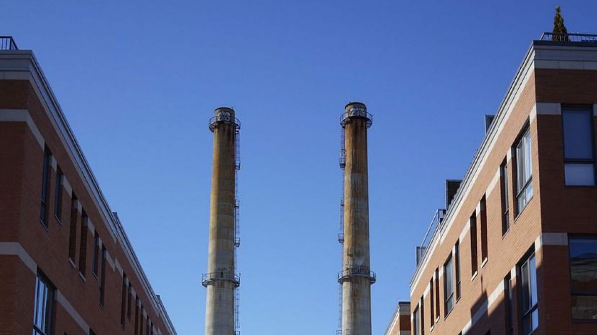 Fabriksgebäude aus Backstein mit zwei hohen Schloten, aus denen kein Rauch kommt.