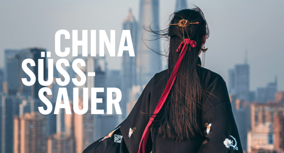 Eine Frau mit schwarzen langen Haaren blickt aus einiger Entfernung auf die Kulisse einer Großstadt und dreht uns dabei den Rücken zu. Sie trägt einen Kimono und eine rote Samtschleife im Haar. Titel: CHINA SÜSS-SAUER